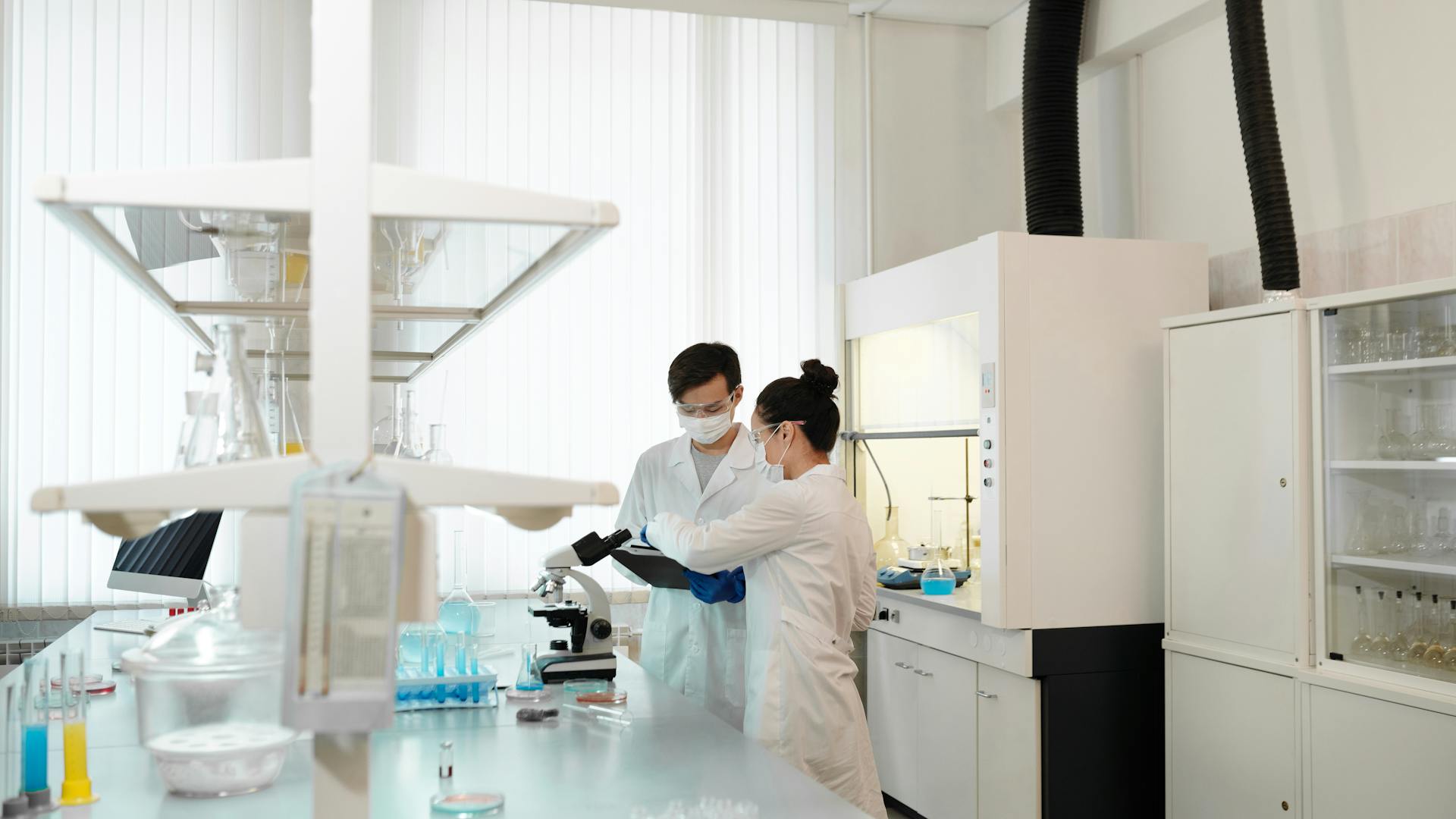 Two scientists working in a laboratory with equipment and supplies.