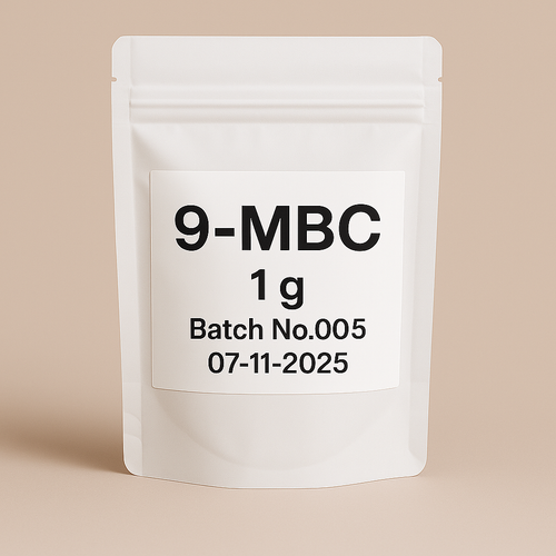 image of a white, resealable stand-up pouch labeled 9-MBC 1g, Batch No.005, dated 07-11-2025. The pouch is placed against a neutral beige background, ideal for supplement product listings or e-commerce use