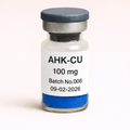 Vial labeled 'AHK-CU 100 mg' with batch number and date on a white background