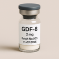 Clear glass vial labeled "GDF-8 2 mg, Batch No.003, 11-07-2025" containing a white lyophilized powder and sealed with a dark gray cap, set against a soft beige background