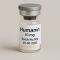 Glass vial labeled 'Humanin 10 mg, Batch No.002, 20-06-2025' containing a white lyophilized powder, sealed with a gray rubber stopper and matte silver cap, photographed against a soft beige background