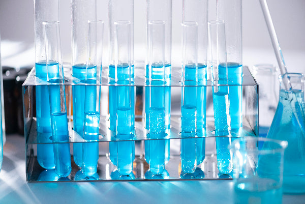 Test tubes with blue liquid in a rack on a lab bench
