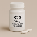 a white pill bottle labeled 'S23 10mg, Batch No.002, Expiry 19-06-2025' with two beige capsules beside it on a neutral beige background